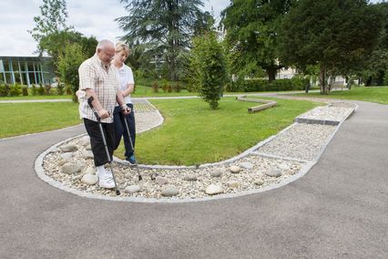 Patient und Physiotherapeutin laufen über Parcours im Park