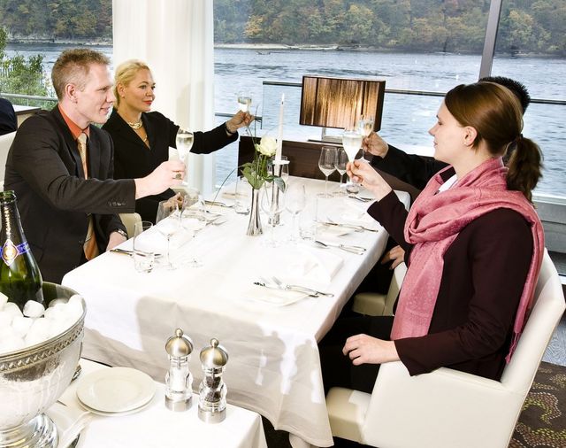 Vier Gäste am Tisch stossen an im Restaurant Bellerive 