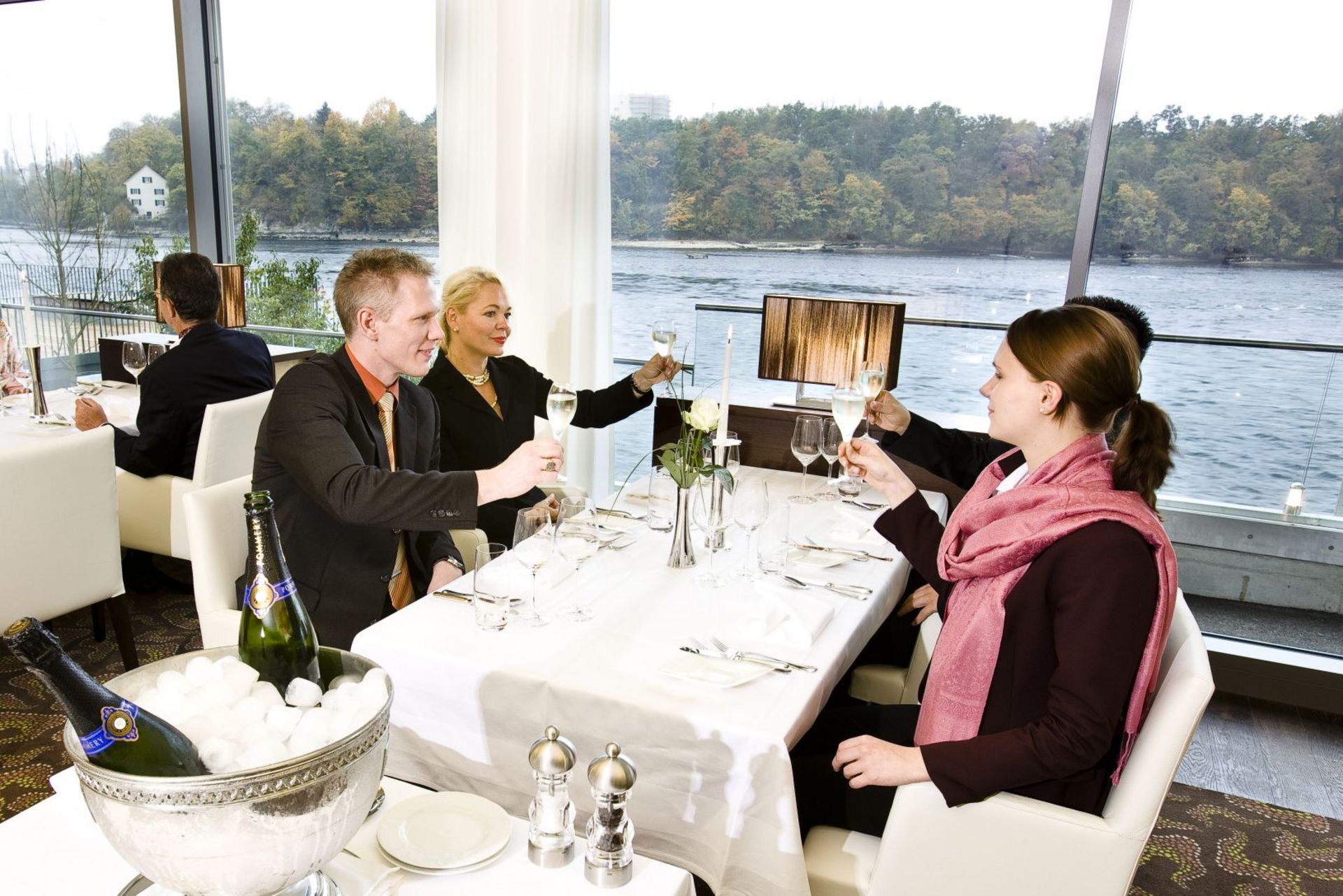 Vier Gäste am Tisch stossen an im Restaurant Bellerive 